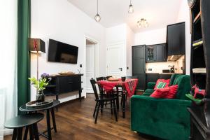 a living room with a green couch and a table at Wooden Horse - New Apartment - Old Town in Krakow