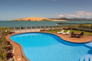a swimming pool with a view of the ocean at The Sands Hotel Hokianga in Opononi