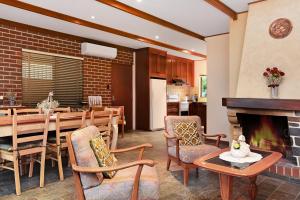 - un salon avec une table et une cheminée dans l'établissement Don Carmella - Aldinga Beach - C21 SouthCoast Holidays, à Aldinga Beach