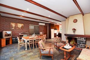 a dining room with a table and a fireplace at Don Carmella - Aldinga Beach - C21 SouthCoast Holidays in Aldinga Beach
