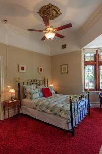The Oaks Lilydale Accommodation في ليليديل: غرفة نوم مع سرير ومروحة سقف