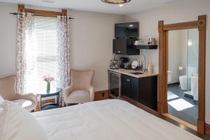 a bedroom with a bed and a kitchen with a counter at The Victorian Luxury Suites in Westport
