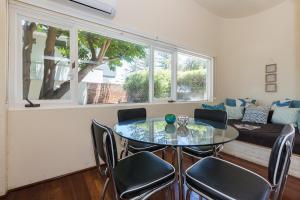 a dining room with a glass table and chairs at Cottesloe Bel-Air Apartment in Perth
