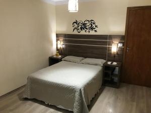 1 dormitorio pequeño con 1 cama y 2 mesitas de noche en GA1-Hospedagem Próximo ao Aeroporto de Guarulhos, en Guarulhos