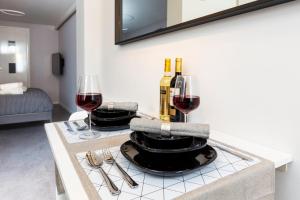 a table with wine glasses and wine bottles on it at Original twin Studio Delft City Central Station 30B in Delft