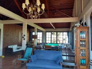 ein Wohnzimmer mit einem blauen Sofa und einem Kronleuchter in der Unterkunft The Cats' House in Florianópolis