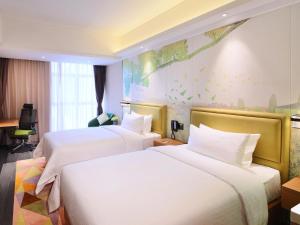 a hotel room with two beds and a desk at Hampton by Hilton Zhuhai Cheng Feng Plaza in Zhuhai