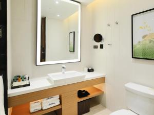 a bathroom with a sink and a mirror at Hampton by Hilton Zhuhai Cheng Feng Plaza in Zhuhai