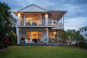 une maison avec un balcon et une pelouse dans l'établissement Serenity Beach Retreat, à Casuarina
