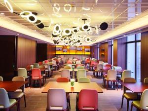 una sala da pranzo con tavoli e sedie di Hampton by Hilton Zhuhai Cheng Feng Plaza a Zhuhai