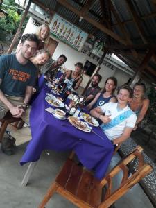 um grupo de pessoas sentadas à volta de uma mesa com comida em Hostal La Cascada em Mérida