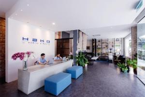 two people sitting at a reception desk in a lobby at Hako Hotel in Skudai