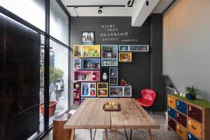 a room with a wooden table and a book shelf at 愛藝宿Art Space in Tainan