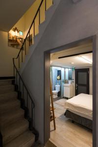 a bedroom with a staircase leading to a bed and a bathroom at 愛藝宿Art Space in Tainan