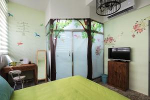 a bedroom with a tree mural on the wall at 愛藝宿Art Space in Tainan