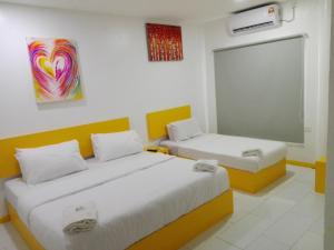 a room with two beds and a chalkboard in it at The Serai Cottage Boutique Hotel in Kuala Berang
