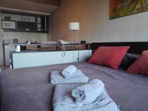 Una cama con toallas encima. en Recoleta SUITE en Buenos Aires