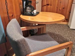 einen Stuhl neben einem Tisch mit Kaffeemaschine in der Unterkunft Park Motel and Cabins in Florence