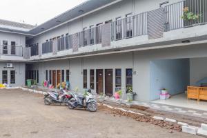 a couple of motorcycles parked in front of a building at RedDoorz near Jatinangor Town Square in Jatinangor