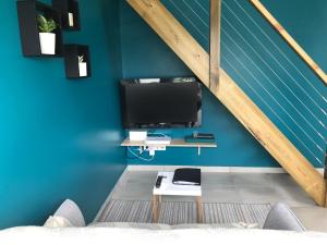 un soggiorno con pareti blu e TV di Bras-Panon: Maison avec vue et piscine 1-4 pers. a Bras-Panon