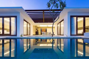a house with a swimming pool in front of it at Prasana by Arjani Resorts in Uluwatu