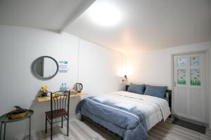 a bedroom with a bed and a desk at Dhub Hostel Donmueng in Bangkok
