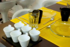 a glass sitting on top of a table with white cups at Il Profumo dei Sensi in Pollica