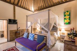 Un dormitorio con una cama con dosel en una habitación. en Taluh Bebek Ubud Private Villas, en Ubud