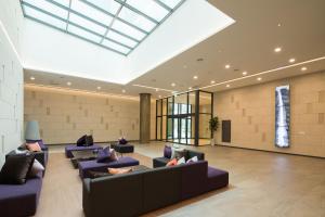 a large lobby with couches and a skylight at Orakai Cheonggyesan Hotel in Seoul