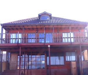 een groot houten gebouw met ramen en een dak bij Hostal Doña Tamy in Quintero