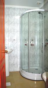 a shower with a glass door in a bathroom at Hostal Doña Tamy in Quintero