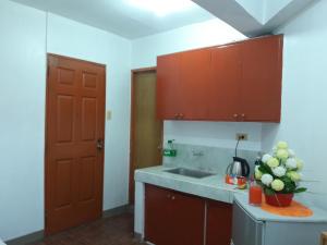 マニラにあるEKONUMI ROOMS at Moonwalk Paranaqueのキッチン(シンク付)、花瓶付きカウンター +29枚の写真