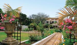 a garden with a vase of flowers on a fence at Fairway Guest House in Durban