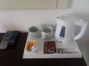 a tray with a blender and two cups and a remote control at Pension Askas in Aegiali