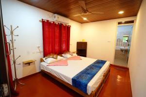 una camera con letto con tenda rossa di Marari Sabari Home Stay a Mararikulam