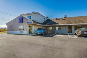 a building with a car parked in a parking lot at Motel 6-Moncton, NB in Moncton