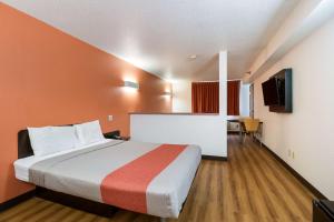 een groot bed in een kamer met oranje muren bij Motel 6-Davenport, IA in Davenport