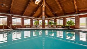 a swimming pool in a large building with windows at Best Western Geneseo Inn in Geneseo