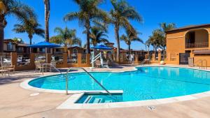 a swimming pool at a resort with palm trees at Best Western Oxnard Inn in Oxnard
