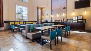 a restaurant with tables and chairs and a bar at Best Western Oxnard Inn in Oxnard