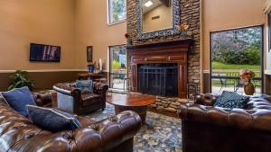 a living room with leather furniture and a fireplace at Best Western Shelbyville Lodge in Shelbyville