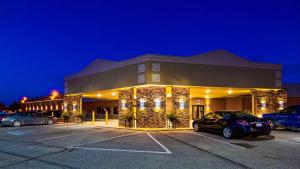 un gran edificio con coches estacionados en un estacionamiento en Best Western Starlite Village en Fort Dodge