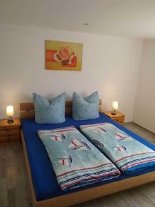 ツィノヴィッツにあるFerienwohnungen im Seebad Zinnowitz-500m zum Strandのベッドルーム1室(青いベッド1台、枕2つ付)