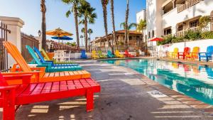 einen Pool mit bunten Stühlen neben einem Hotel in der Unterkunft Best Western Plus Hacienda Hotel Old Town in San Diego