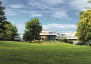 ein Gebäude mit einem grünen Feld davor in der Unterkunft Best Western Plus Parkhotel Velbert in Velbert