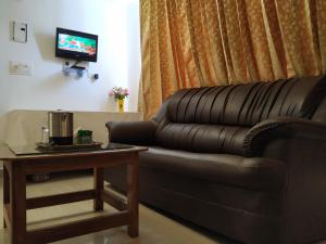 a living room with a couch and a table at Aum Hotel in Puttaparthi