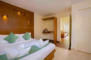 a bedroom with a bed with white flowers on it at Letstay Adithya Nature Resort & Spa in Vythiri