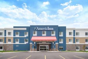 un grande edificio blu con un cartello per American Inn di AmericInn by Wyndham Windom a Windom