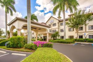 eine Darstellung der Vorderseite eines Hotels mit Palmen in der Unterkunft Hawthorn Suites by Wyndham Naples in Naples