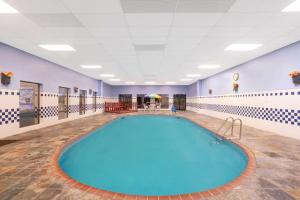 einen großen Pool in einem Fitnessraum mit lila Wänden in der Unterkunft Super 8 by Wyndham North Little Rock/McCain in North Little Rock